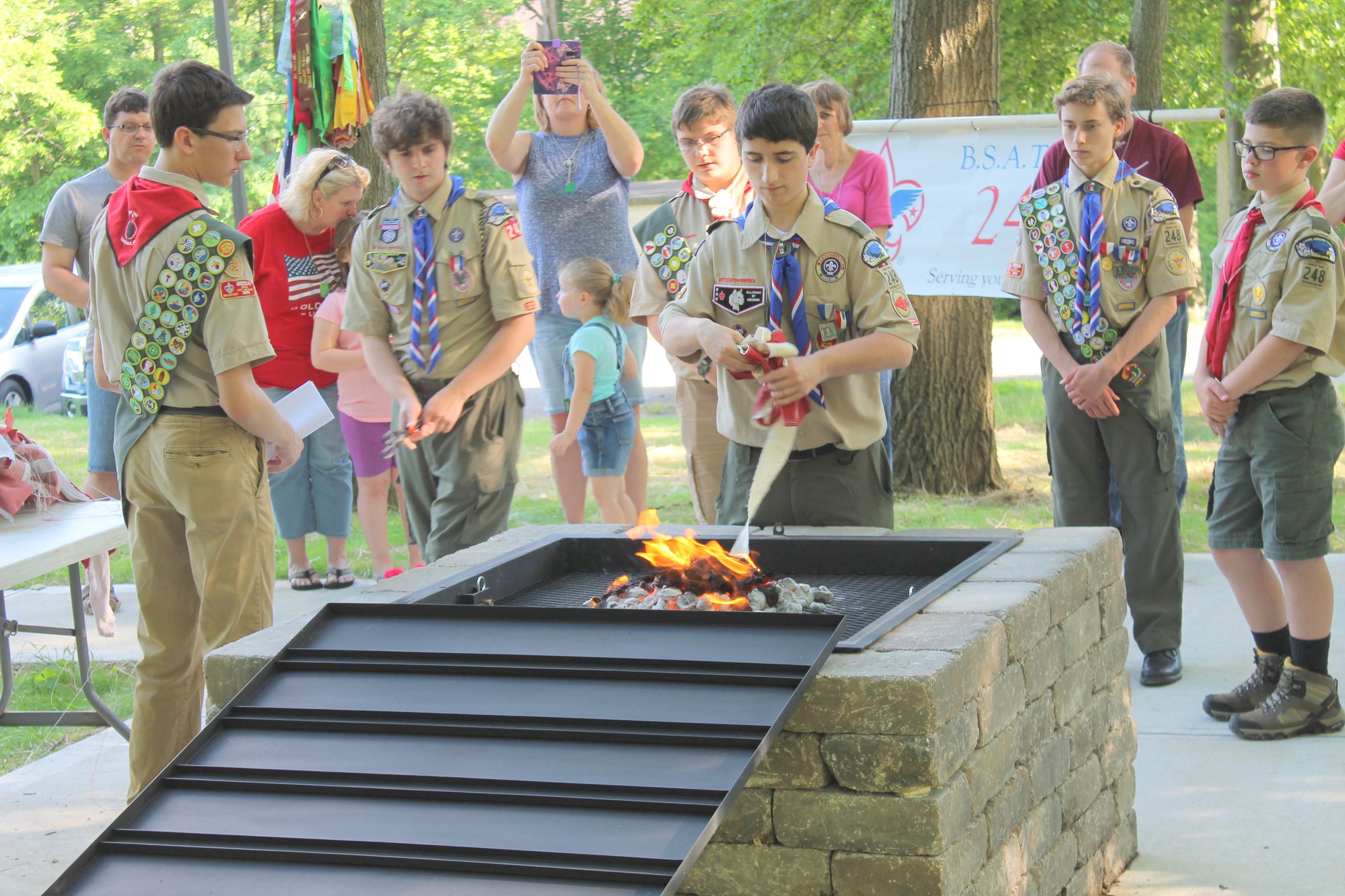 Scout places flag in fire