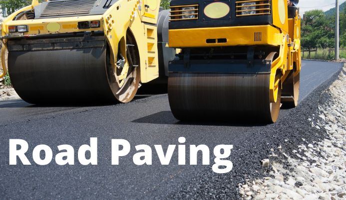 Equipment rolling over new paving with text Road Paving